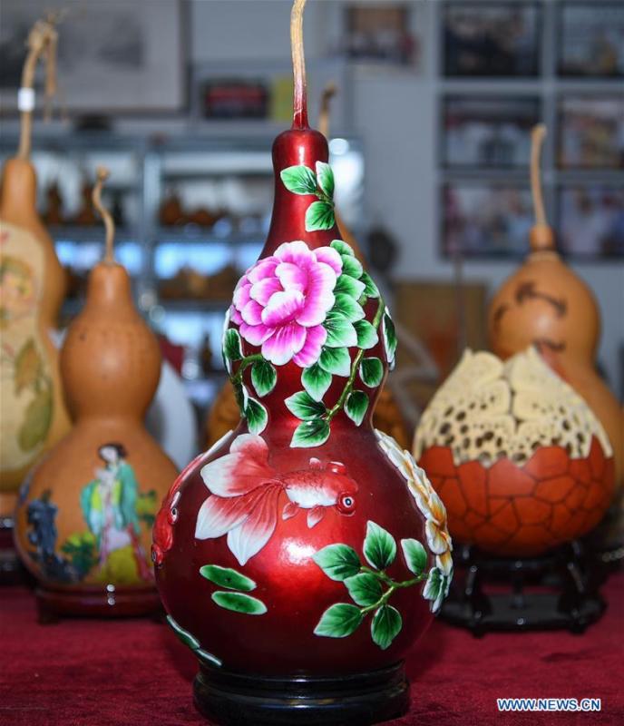 Wang Guowei\'s gourd handicrafts are seen at his studio in Tieling, northeast China\'s Liaoning Province, Nov. 26, 2018. Wang Guowei who is adept in painting was awarded provincial-level handicraft master title for producing exquisite gourd handicrafts with vivid images. (Xinhua/Long Lei)