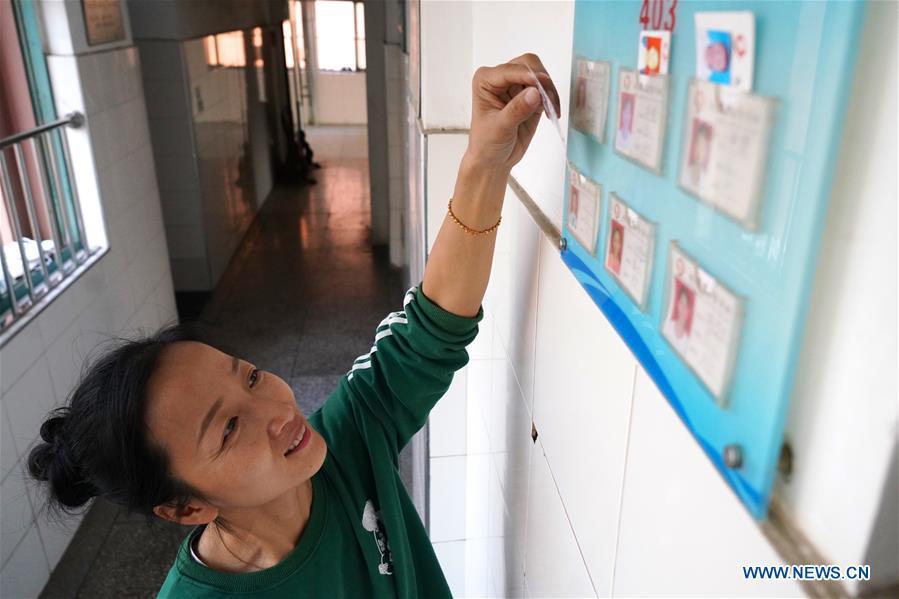 Teacher Zeng Wenping rearranges students\' information at Qiyin school in Nanchang, capital of east China\'s Jiangxi Province, Nov. 26, 2018. Zeng, 43, has been engaged in special education for 21 years ever since she graduated from university. Hearing impaired students enjoy the all-encompassing heartfelt and intensive care by Zeng and consider her as more than a teacher but a sister. (Xinhua/Hu Chenhuan)