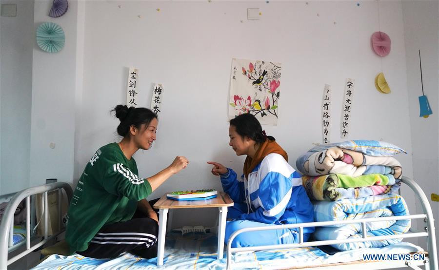 Teacher Zeng Wenping (L) plays Chinese checkers with a student at Qiyin school in Nanchang, capital of east China\'s Jiangxi Province, Nov. 26, 2018. Zeng, 43, has been engaged in special education for 21 years ever since she graduated from university. Hearing impaired students enjoy the all-encompassing heartfelt and intensive care by Zeng and consider her as more than a teacher but a sister. (Xinhua/Hu Chenhuan)