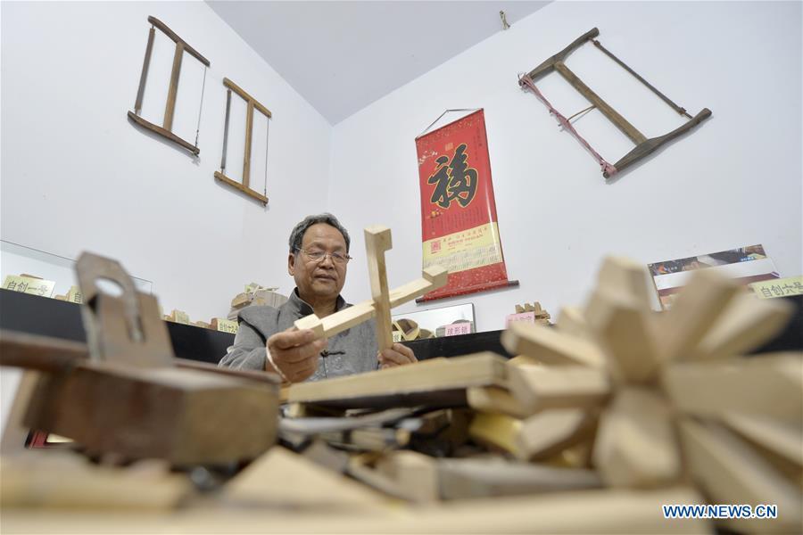 Hou Quanchen designs a Kong Ming Lock in Shahe City, north China\'s Hebei Province on Nov. 28, 2018. Hou Quanchen, who is in his seventies, has devoted himself in the studying and making of Kong Ming Locks and has tried to promote this art among local residents ever since his retirement. (Xinhua/Tian Xiaoli)