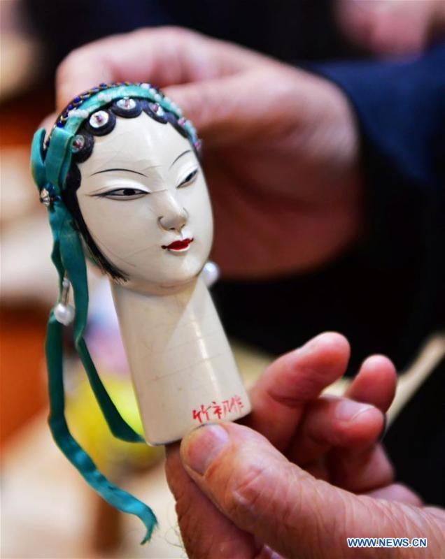 Xu Zhuchu, a national-level intangible cultural heritage inheritor of Zhangzhou wood puppet head carving, displays a wood puppet head at a studio in Zhangzhou City, southeast China\'s Fujian Province, Nov. 28, 2018. Listed as one of the national intangible cultural heritages in 2006, Zhangzhou wood puppet carving features exquisite craftsmanship. Xu\'s works of puppet head carving are known for rich and delicate facial expressions. Nowadays, Xu and his son, Xu Qiang, set up a studio of wood puppet to popularize local puppet culture. (Xinhua/Wei Peiquan)