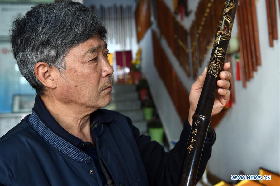 Liu Zesong, inheritor of the Yuping bamboo flute making craft, introduces a flute he made in Yuping Dong Autonomous County, southwest China\'s Guizhou Province, Nov. 29, 2018. As a traditional Chinese bamboo instrument, Yuping bamboo flute is famous for its clear tone and delicate carving. Made from local bamboo, the flute goes through dozens of procedures before finished and merges folk cultures of other ethnic groups. It was listed as one of the National Intangible Cultural Heritages in 2006. (Xinhua/Ma Ning)