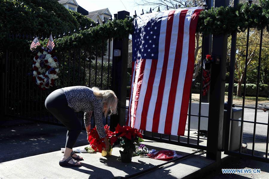 A woman lays flowers at the gate of the residence of former U.S. President George H.W. Bush in Houston, Texas, the United States, on Dec. 1, 2018. George H.W. Bush, the 41st president of the United States, has died Friday at the age of 94, according to a statement from his office. (Xinhua/Steven Song)