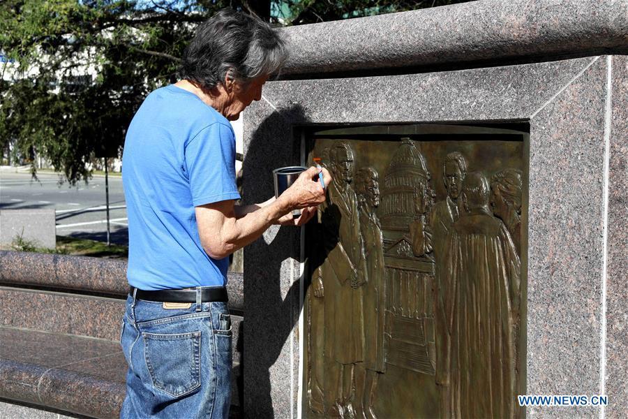 A Houston municipal staff member cleans a relief of former U.S. President George H.W. Bush in Houston, Texas, the United States, on Dec. 1, 2018. George H.W. Bush, the 41st president of the United States, has died Friday at the age of 94, according to a statement from his office. (Xinhua/Steven Song)