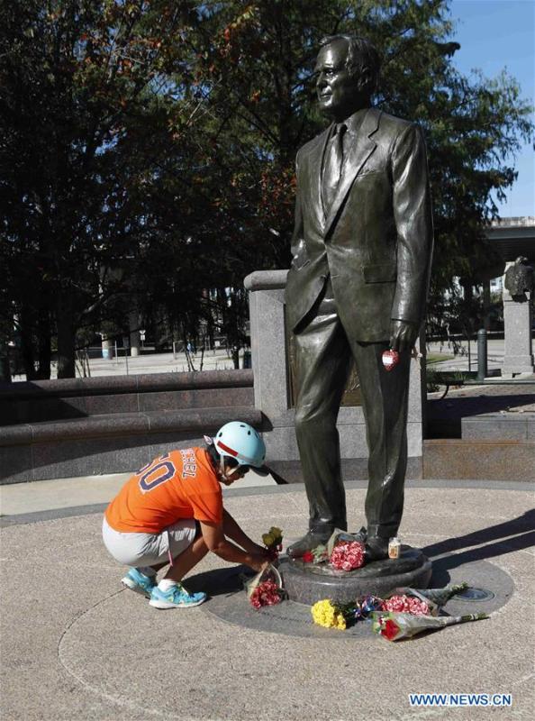 A citizen lays flowers in front of a statue of former U.S. President George H.W. Bush in Houston, Texas, the United States, on Dec. 1, 2018. George H.W. Bush, the 41st president of the United States, has died Friday at the age of 94, according to a statement from his office. (Xinhua/Steven Song)
