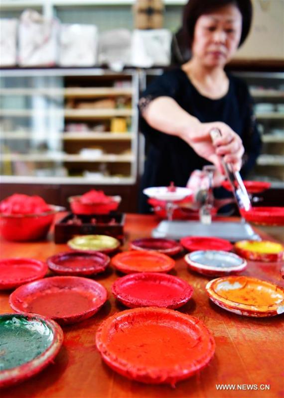 A worker fills Babao red ink paste into saucers in Zhangzhou, southeast China\'s Fujian Province, Nov. 30, 2018. Made of many precious materials such as pearl, agate, coral and musk, Zhangzhou red ink paste has been favoured by painters and calligraphers both home and abroad for over 300 years. Its making technology was listed as the second batch of national intangible cultural heritages in 2008. (Xinhua/Wei Peiquan)