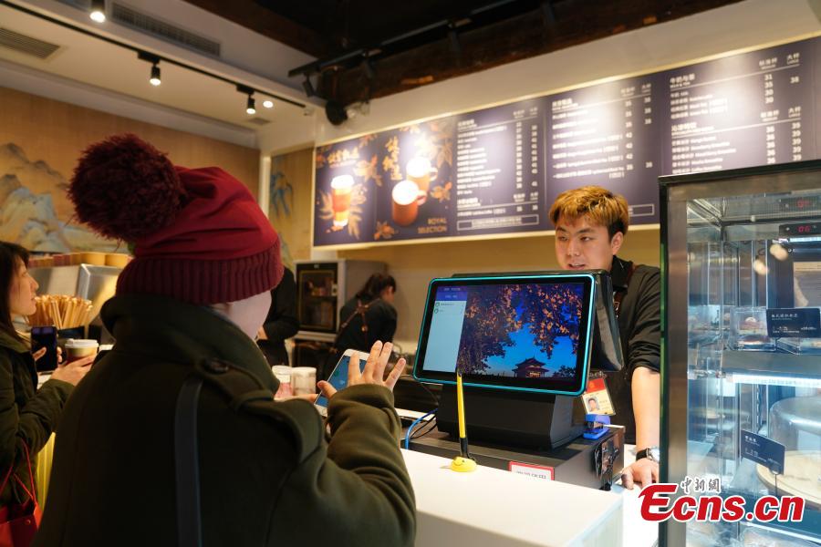 A girl orders food at a café opened outside the Palace Museum\'s Shenwu Men, or the Gate of Divine Might in Beijing on December 1, 2018. Named “Café by The Forbidden City”, the coffee shop in the theme of imperial China enables their customers to enjoy a wide range of drinks while experiencing ancient Chinese culture.  (Photo: China News Service/ Du Yang)