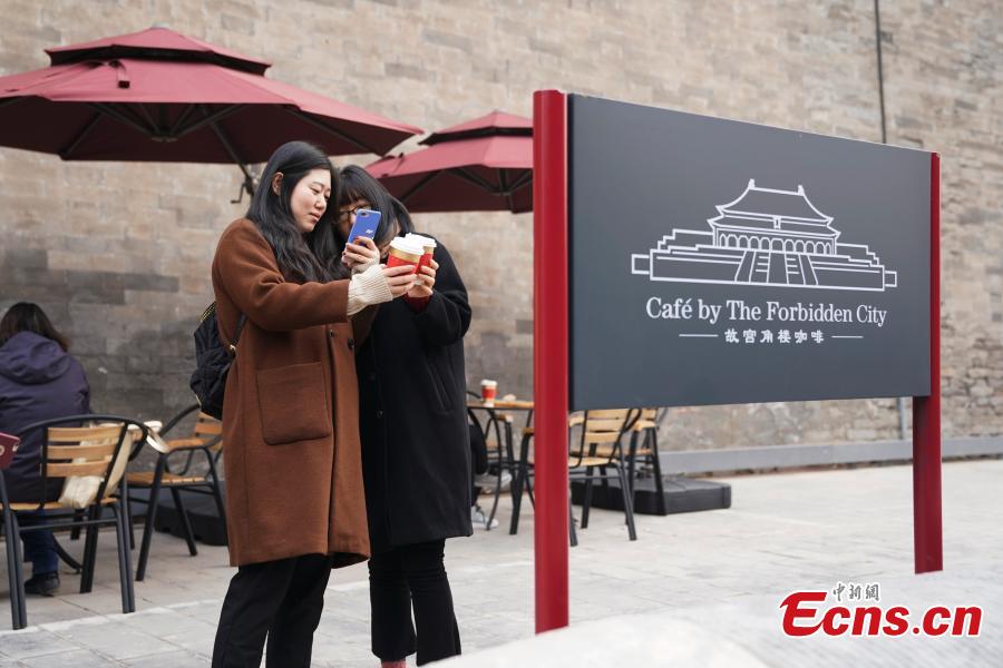 Girls take selfies outside a café newly opened outside the Palace Museum\'s Shenwu Men, or the Gate of Divine Might in Beijing on December 1, 2018. Named “Café by The Forbidden City”, the coffee shop in the theme of imperial China enables their customers to enjoy a wide range of drinks while experiencing ancient Chinese culture.  (Photo: China News Service/ Du Yang)