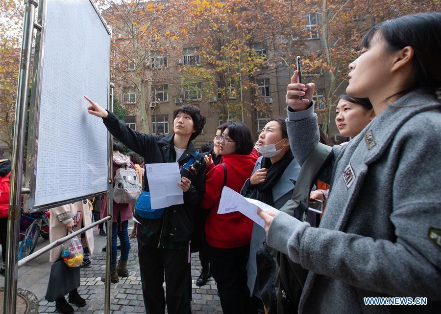 Candidates check exam information before taking the national civil servant exam at Nanjing Forestry University in Nanjing, capital of east China\'s Jiangsu Province, Dec. 2, 2018. The written exam of the national civil servant exam was held on Sunday across the country. (Xinhua/Su Yang)
