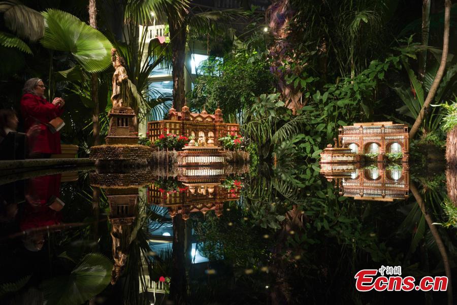 Visitors are attracted by model trains navigating painstakingly crafted miniatures of New York City’s built environment, all made entirely out of plant parts at Holiday Train Show in New York on December 1, 2018. At the show, model trains zip through a display of more than 175 New York landmarks, each re-created with bark, leaves, and other natural materials. (Photo: China News Service/Liao Pan)
