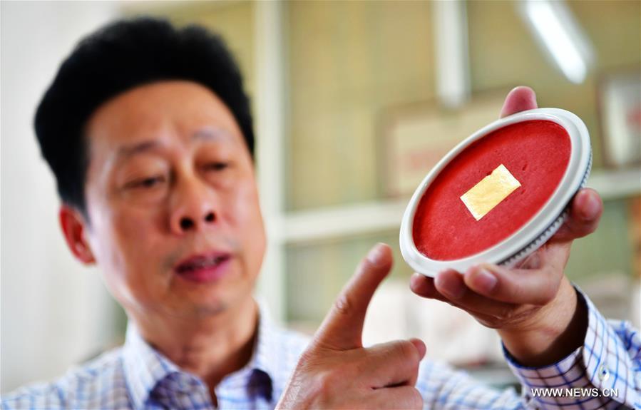 Yang Xiwei, the inheritor of Zhangzhou Babao red ink paste making technique, shows a saucer of ink paste in Zhangzhou, southeast China\'s Fujian Province, Nov. 30, 2018. Made of many precious materials such as pearl, agate, coral and musk, Zhangzhou red ink paste has been favoured by painters and calligraphers both home and abroad for over 300 years. Its making technology was listed as the second batch of national intangible cultural heritages in 2008. (Xinhua/Wei Peiquan)