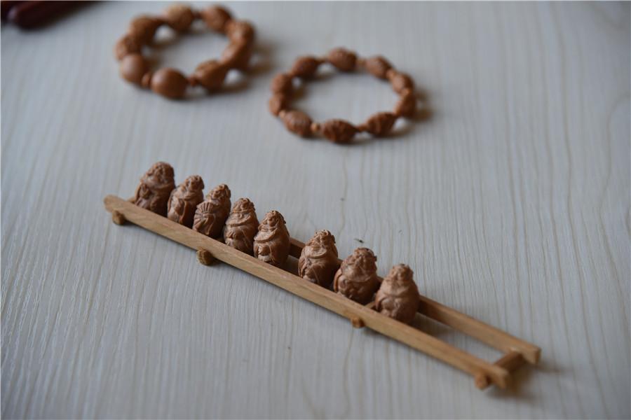 Zhu Haiyang does olive pit carving at his home in September of last year. (Photo by Qian Lei for chinadaily.com.cn)
