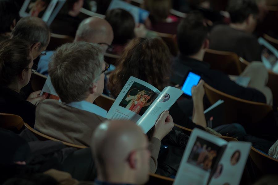 An audience member reads from the program for the 8th Traditional Chinese Opera Festival in Paris on Nov. 26, 2018. (Photo/Chinaculture.org)