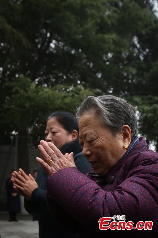 Survivor of the Nanjing Massacre Shi Xiuying, 92, pays tribute to the victims of the Nanjing Massacre before the memorial hall wall where the victims\' names are engraved during commemoration activities in Nanjing, capital of east China\'s Jiangsu Province, Dec. 3, 2018. The Nanjing Massacre took place when Japanese troops captured the city on Dec. 13, 1937. Over six weeks, they killed 300,000 Chinese civilians and unarmed soldiers. In February 2014, China\'s top legislature designated December 13 as the national memorial day for victims of the Nanjing Massacre. Starting Monday, family members of the victims began a series of commemoration activities such as laying flowers, burning incense and reading letters in front of the Memorial Hall of the Victims in Nanjing Massacre by Japanese Invaders.(Photo: China News Service/Yang Bo)