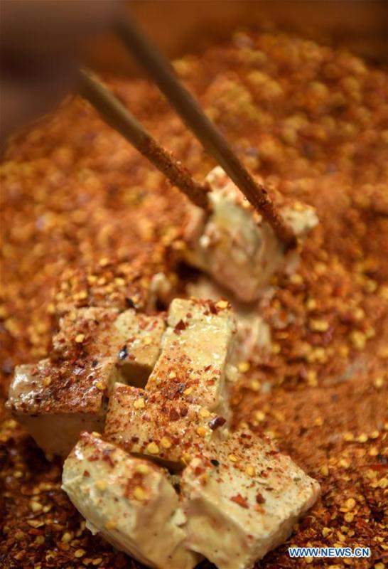 Local resident Yi Yinjie adds spices to \