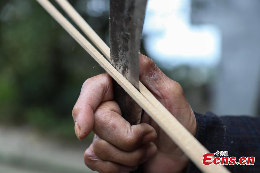 78-year-old Song Erfeng chops bamboo into long and thin filaments in preparation for materials to make bamboo hats in a village in Tangtou town, Southwest China\'s Guizhou province on December 3, 2018.  As an inheritor of bamboo hat making skills, Song has been practicing the craft for 70 years. Being made with bamboo filaments as thin as hair, the special hat has a history that can be traced back to Ming Dynasty (1368-1644). (Photo: China News Service/ Qu Honglun)