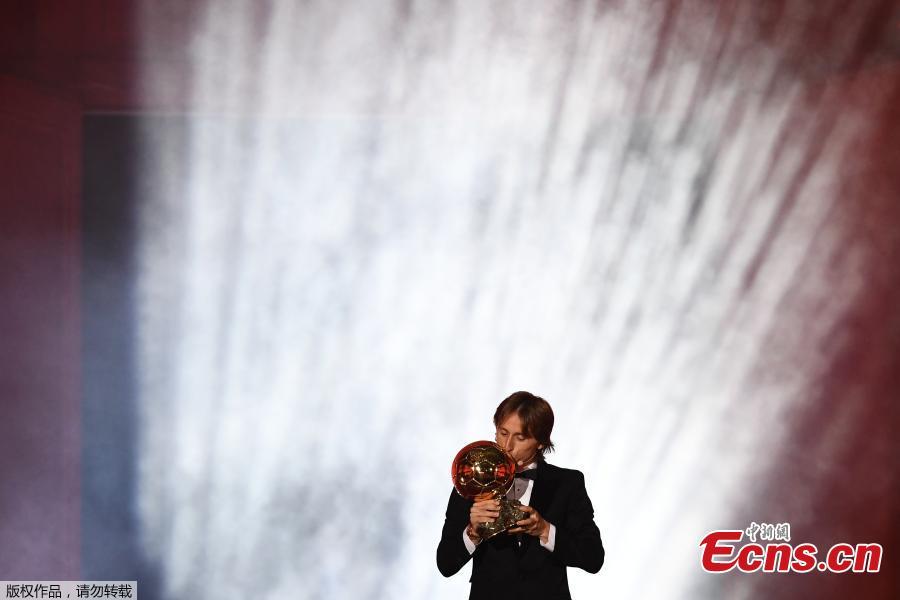 Real Madrid\'s Croatian midfielder Luka Modric kisses the trophy after receiving the 2018 FIFA Men\'s Ballon d\'Or award for best player of the year during the 2018 FIFA Ballon d\'Or award ceremony at the Grand Palais in Paris on December 3, 2018. The winner of the 2018 Ballon d\'Or will be revealed at a glittering ceremony in Paris on December 3 evening, with Croatia\'s Luka Modric and a host of French World Cup winners all hoping to finally end the 10-year duopoly of Cristiano Ronaldo and Lionel Messi.  (Photo/Agencies)