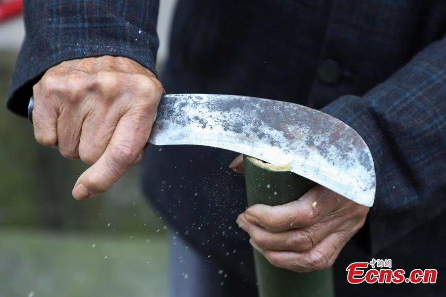 78-year-old Song Erfeng chops bamboo into long and thin filaments in preparation for materials to make bamboo hats in a village in Tangtou town, Southwest China\'s Guizhou province on December 3, 2018.  As an inheritor of bamboo hat making skills, Song has been practicing the craft for 70 years. Being made with bamboo filaments as thin as hair, the special hat has a history that can be traced back to Ming Dynasty (1368-1644). (Photo: China News Service/ Qu Honglun)