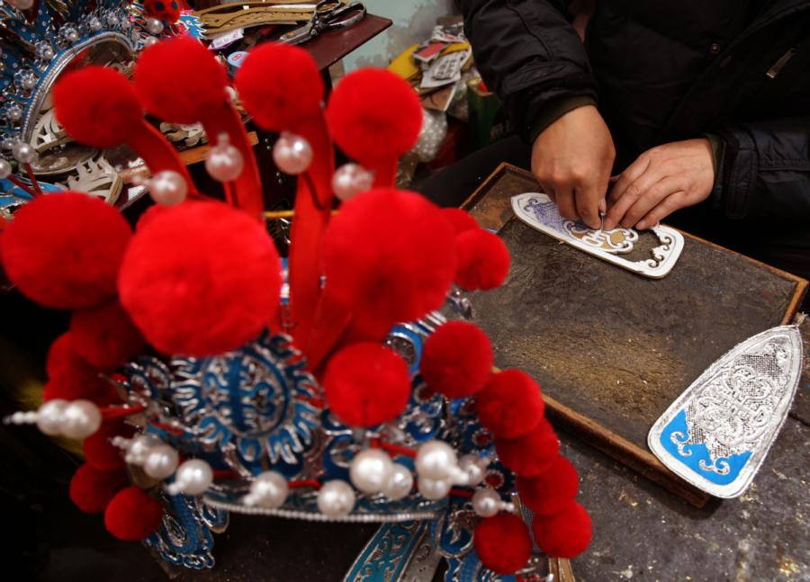 Han needs at least three days to finish a hand-made headwear piece. (Photo by Huo Yan/chinadaily.com.cn)