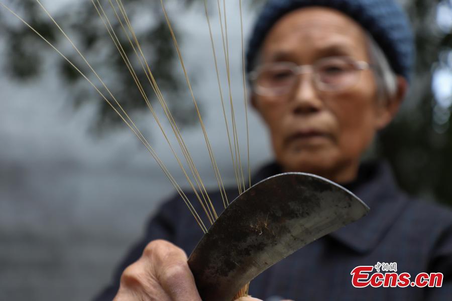 78-year-old Song Erfeng chops bamboo into long and thin filaments in preparation for materials to make bamboo hats in a village in Tangtou town, Southwest China\'s Guizhou province on December 3, 2018.  As an inheritor of bamboo hat making skills, Song has been practicing the craft for 70 years. Being made with bamboo filaments as thin as hair, the special hat has a history that can be traced back to Ming Dynasty (1368-1644). (Photo: China News Service/ Qu Honglun)