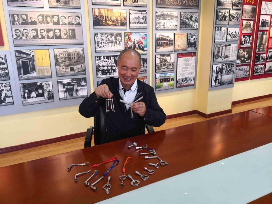 Sun Mingjin presents his collection of train keys.  (Photo by Qu Xiaoxi for chinadaily.com.cn)