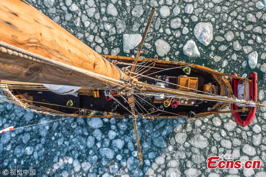British photographer James Rushworth captured the moment when a schooner passed by a giant iceberg off the east coast of Greenland. The 108-foot-long schooner was dwarfed by the 300-foot-tall turquoise iceberg. The 32-year-old photographer braved temperature of minus 10 degrees Celsius as he waited for the vessel to reach the center of the arch of the iceberg. (Photo/VCG)