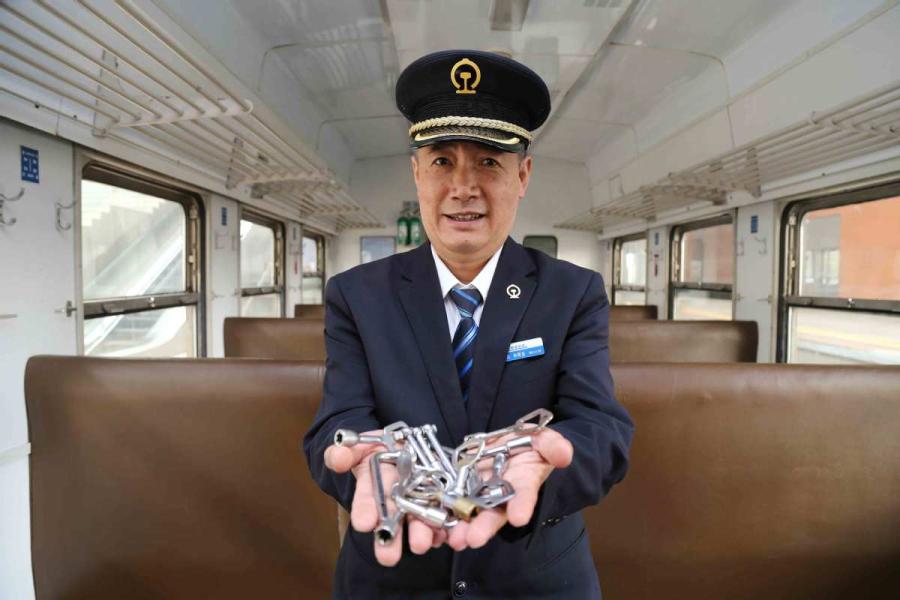 Sun Mingjin presents his collection of train keys. (Photo by Qu Xiaoxi for chinadaily.com.cn)