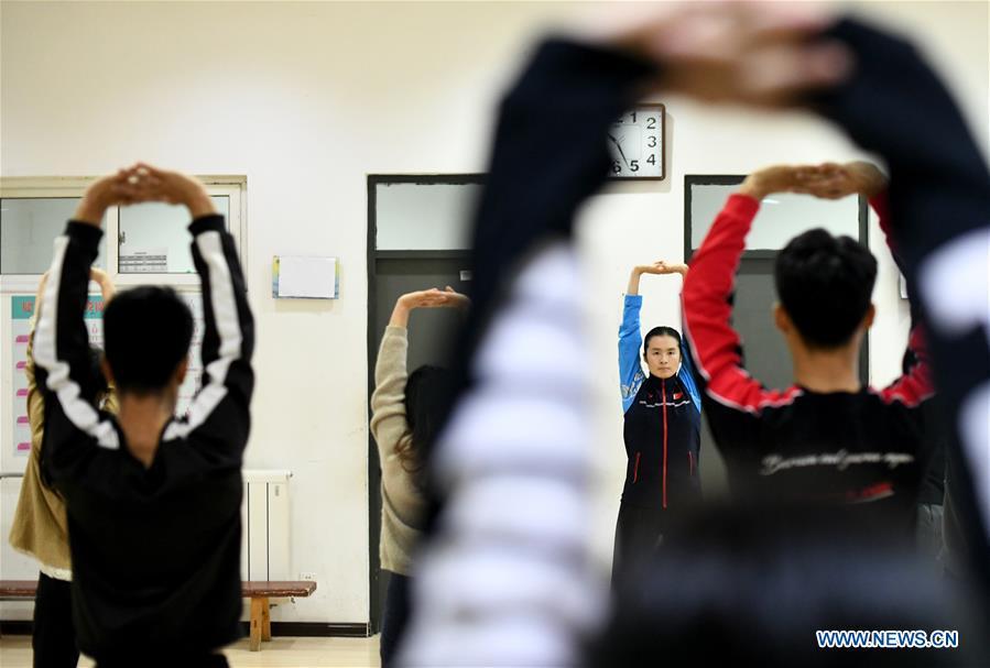Huo Jinghong, the 5th generation descendant of Huo Yuanjia, a Chinese martial arts master, demonstrates health Qigong, a traditional martial art combined with meditation, for students at Tianjin University of Commerce in Tianjin, north China, Nov. 26, 2018. As the descendant of Huo Yuanjia, one of China\'s most revered martial arts masters, Huo Jinghong, 41, started practicing martial arts at the age of 5. After her graduation from the Wushu School of Beijing Sport University in major of Wushu Routine, Huo started her career as a gym teacher of Tianjin University of Commerce in the year of 2000. As a gym teacher, Huo teaches martial arts for the university team and offers classes on health Qigong, a new form selected from different versions of traditional Qigong for modern fitness, in the university. Later in 2015, Huo became the inheritor of Huo-style boxing, which was listed as an intangible cultural heritage in Tianjin, and since then, she has devoted herself to the inheritance and development of the martial arts handed down from the older generation of Huo\'s family. She hoped that the Huo-style boxing would help people understand more about the Chinese martial arts. Huo Yuanjia was born in Tianjin in 1868. He founded the Chin Woo Athletic Association in 1910 in Shanghai and advocated the spirit of \