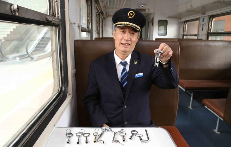 Sun Mingjin presents his collection of train keys.  (Photo by Qu Xiaoxi for chinadaily.com.cn)