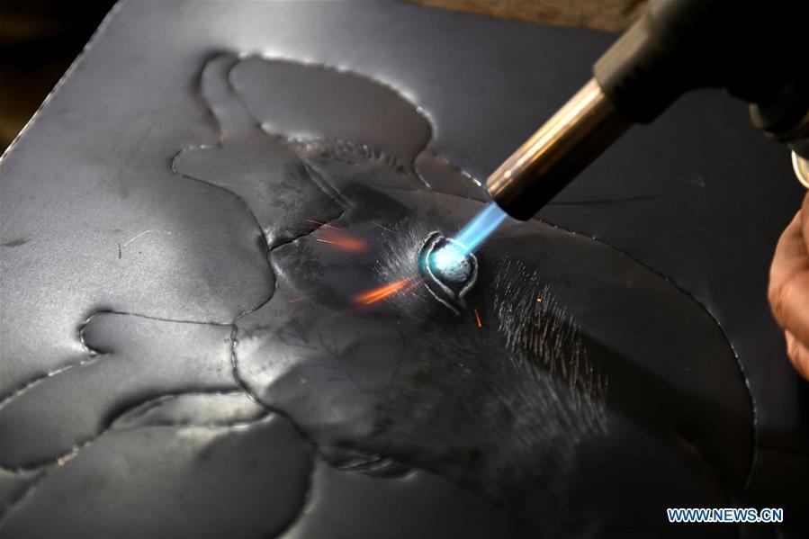 Guo Hailong, inheritor of welding-aided iron relief handicraft, works at his workshop in Deming ancient town of Shijiazhuang, capital of north China\'s Hebei Province, on Dec. 4, 2018. The craftsmanship was listed as the provincial intangible cultural heritage in 2013. (Xinhua/Chen Qibao)