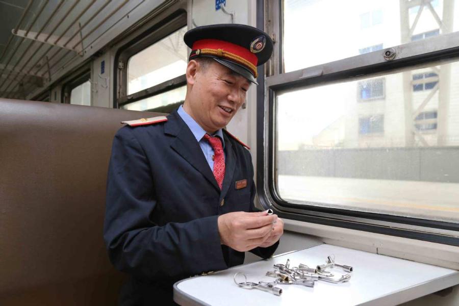Sun Mingjin presents his collection of train keys. (Photo by Qu Xiaoxi for chinadaily.com.cn)