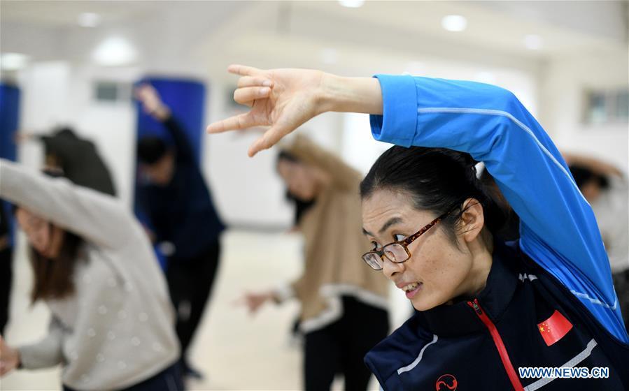 Huo Jinghong, the 5th generation descendant of Huo Yuanjia, a Chinese martial arts master, demonstrates health Qigong, a traditional martial art combined with meditation, for students at Tianjin University of Commerce in Tianjin, north China, Nov. 26, 2018. As the descendant of Huo Yuanjia, one of China\'s most revered martial arts masters, Huo Jinghong, 41, started practicing martial arts at the age of 5. After her graduation from the Wushu School of Beijing Sport University in major of Wushu Routine, Huo started her career as a gym teacher of Tianjin University of Commerce in the year of 2000. As a gym teacher, Huo teaches martial arts for the university team and offers classes on health Qigong, a new form selected from different versions of traditional Qigong for modern fitness, in the university. Later in 2015, Huo became the inheritor of Huo-style boxing, which was listed as an intangible cultural heritage in Tianjin, and since then, she has devoted herself to the inheritance and development of the martial arts handed down from the older generation of Huo\'s family. She hoped that the Huo-style boxing would help people understand more about the Chinese martial arts. Huo Yuanjia was born in Tianjin in 1868. He founded the Chin Woo Athletic Association in 1910 in Shanghai and advocated the spirit of \