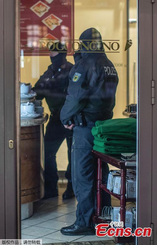 Masked police stand in an ice parlor in Duisburg, western Germany, Wednesday, Dec. 5, 2018 as authorities conduct coordinated raids in Germany, Italy, Belgium and the Netherlands in a crackdown on the Italian mafia. (Photo/Agencies)