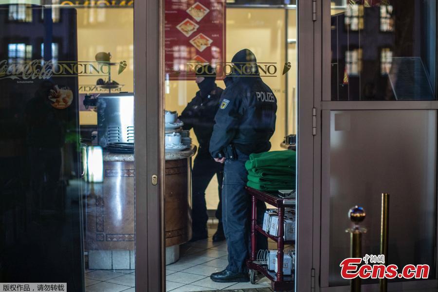 Masked police stand in an ice parlor in Duisburg, western Germany, Wednesday, Dec. 5, 2018 as authorities conduct coordinated raids in Germany, Italy, Belgium and the Netherlands in a crackdown on the Italian mafia. (Photo/Agencies)