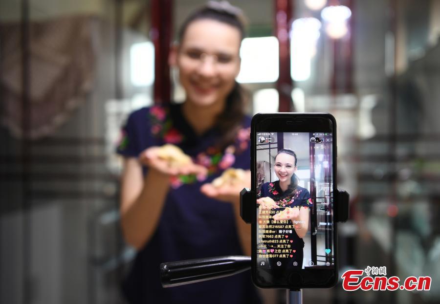 Valentina, a 26-year-old girl Russia speaks to her audience while making dumplings through live video streaming platforms at her home in Changchu, Northeast China’s Jilin province. As a fan of Chinese food and culture, Valentina found her husband on the internet and then settled down in Changchun. Valentina said at the beginning she hosted live streams to get more chance to talk with audience, so as to learn Chinese better. After knowing the audience liked to watch her cooking and painting, Valentina started to broadcast her daily routines, and now she had over 200,000 followers. (Photo: China News Service/ Zhang Yao)