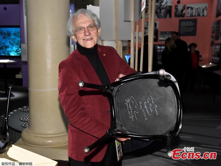 The Nobel Prize laureate in Physics Gerard Mourou holds a chair he has signed at the Nobel Museum in Stockholm, Sweden on December 6, 2018.(Photo/Agencies)