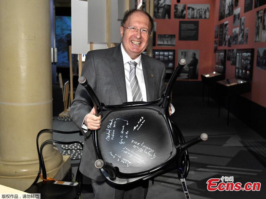 The Nobel Prize laureate in chemistry Gregory P. Winter holds a chair he has signed at the Nobel Museum in Stockholm, Sweden on December 6, 2018. (Photo/Agencies)