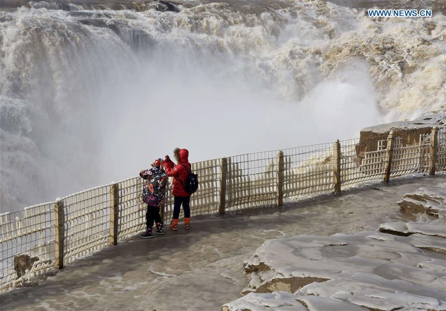 Visitors take photos of icicles at the Hukou Waterfall scenic spot of the Yellow River at the border area between north China\'s Shanxi Province and northwest China\'s Shaanxi Province on Dec. 7, 2018. (Xinhua/Lyu Guiming)