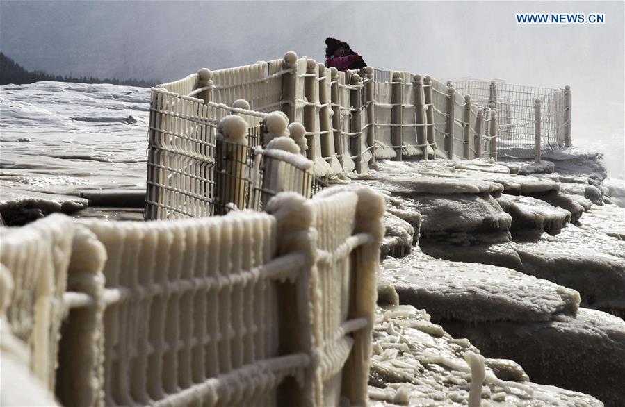 Visitors take photos of icicles at the Hukou Waterfall scenic spot of the Yellow River at the border area between north China\'s Shanxi Province and northwest China\'s Shaanxi Province on Dec. 7, 2018. (Xinhua/Lyu Guiming)