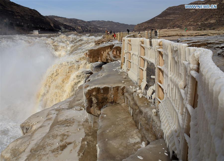 People visit the Hukou Waterfall scenic spot of the Yellow River at the border area between north China\'s Shanxi Province and northwest China\'s Shaanxi Province on Dec. 7, 2018. (Xinhua/Lyu Guiming)
