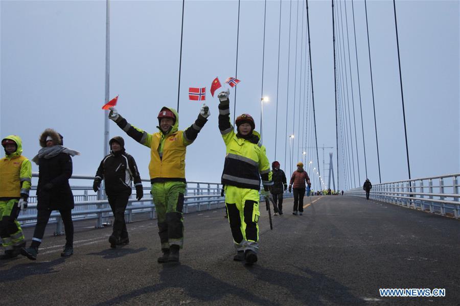 Chinese workers and Norwegian citizens walk on the Halogaland Bridge near Norway\'s northern port city of Narvik, Dec. 9, 2018. A ceremony was held Sunday to officially open Norway\'s second largest bridge that has been built by a Chinese company and its partners some 220 km inside the Arctic Circle. With a total length of 1,533 meters and a free span of 1,145 meters, the Halogaland Bridge near Norway\'s northern port city of Narvik is the longest suspension bridge within the Arctic Circle. (Xinhua/Liang Youchang)