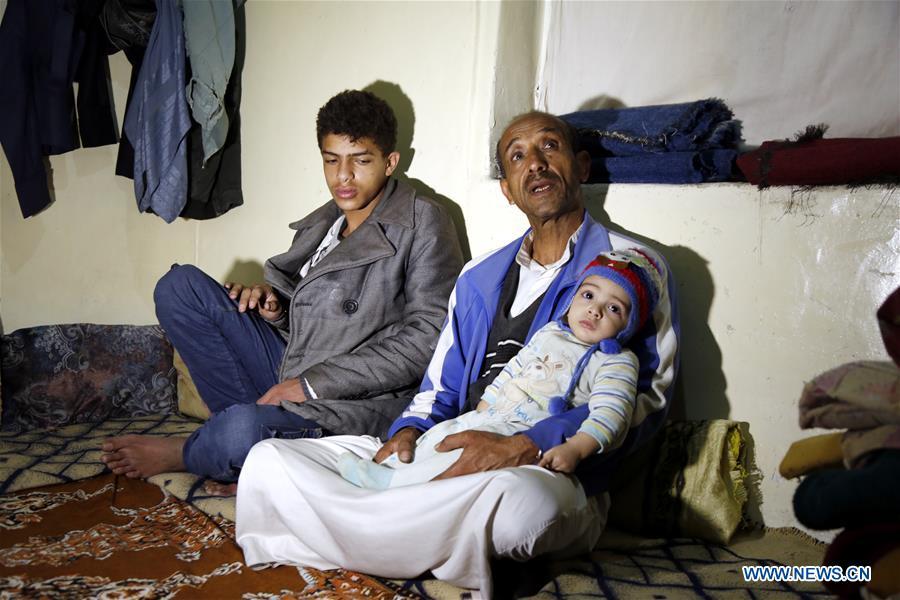 Ahmed al-Sharafi (C) holding his seven-month-old child Omar sits with his son Rami, 16, inside his house in Sanaa, Yemen, on Dec. 9, 2018. An estimated 85,000 children under the age of five may have died from extreme hunger between April 2015 and October 2018, according to the latest data released by Save the Children, an international organization for children\'s rights. (Xinhua/Mohammed Mohammed)