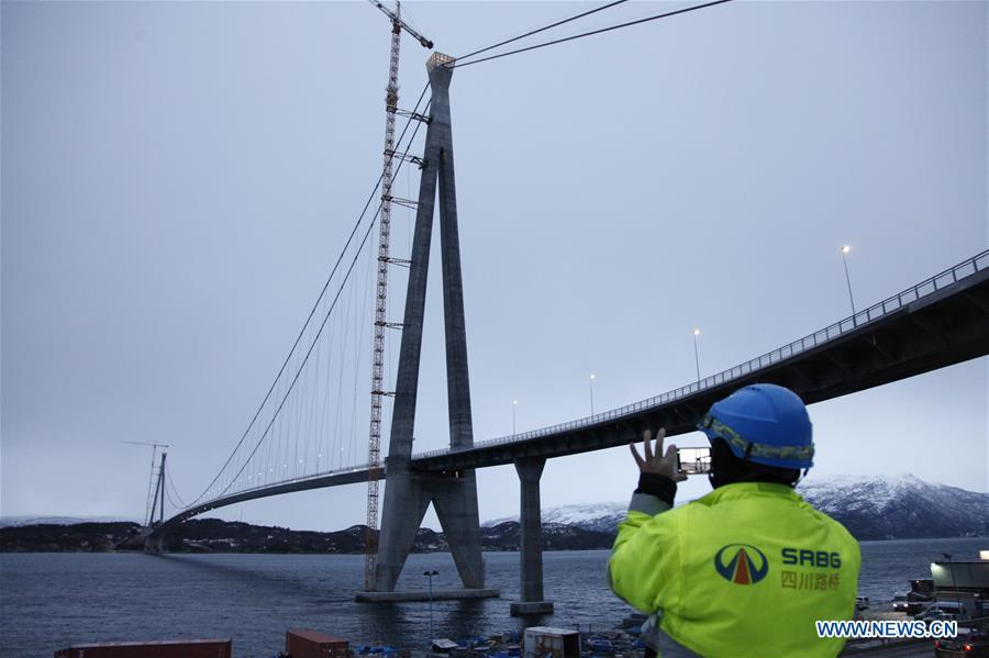 A Chinese worker takes photos of the Halogaland Bridge near Norway\'s northern port city of Narvik, Dec. 9, 2018. A ceremony was held Sunday to officially open Norway\'s second largest bridge that has been built by a Chinese company and its partners some 220 km inside the Arctic Circle. With a total length of 1,533 meters and a free span of 1,145 meters, the Halogaland Bridge near Norway\'s northern port city of Narvik is the longest suspension bridge within the Arctic Circle. (Xinhua/Liang Youchang)