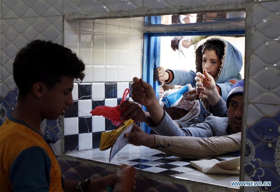Yemeni people gather in front of a window of a charity center to receive food aid in Sanaa, Yemen, on Dec. 9, 2018. An estimated 85,000 children under the age of five may have died from extreme hunger between April 2015 and October 2018, according to the latest data released by Save the Children, an international organization for children\'s rights. (Xinhua/Mohammed Mohammed)