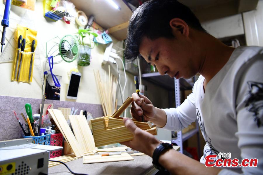Xu Ruibin works with bamboo skewers for a creation at his wonton restaurant in Shijiazhuang City, Hebei Province, Dec. 10, 2018. Xu said he taught himself the handicraft in three months and is now able to make various designs. In the past two years, he has created over 300 works, including landmark buildings and elaborate villa miniatures. (Photo: China News Service/Zhai Yujia)