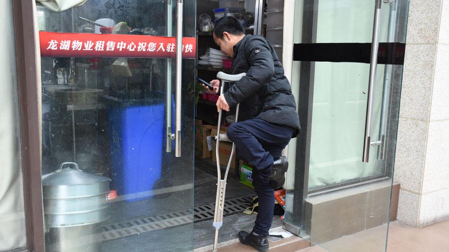 Chen Dengchao, 29, a delivery man in southwestern China\'s Chongqing city, waits for his delivery parcels at a restaurant. (Photo by Li Jiaqi for chinadaily.com.cn)
\