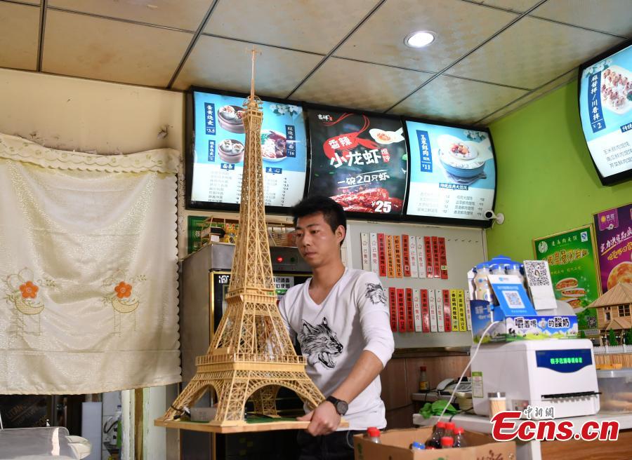 Xu Ruibin shows a replica of the Eiffel Tower made using bamboo skewers in two months at his wonton restaurant in Shijiazhuang City, Hebei Province, Dec. 10, 2018. Xu said he taught himself the handicraft in three months and is now able to make various designs. In the past two years, he has created over 300 works, including landmark buildings and elaborate villa miniatures. (Photo: China News Service/Zhai Yujia)