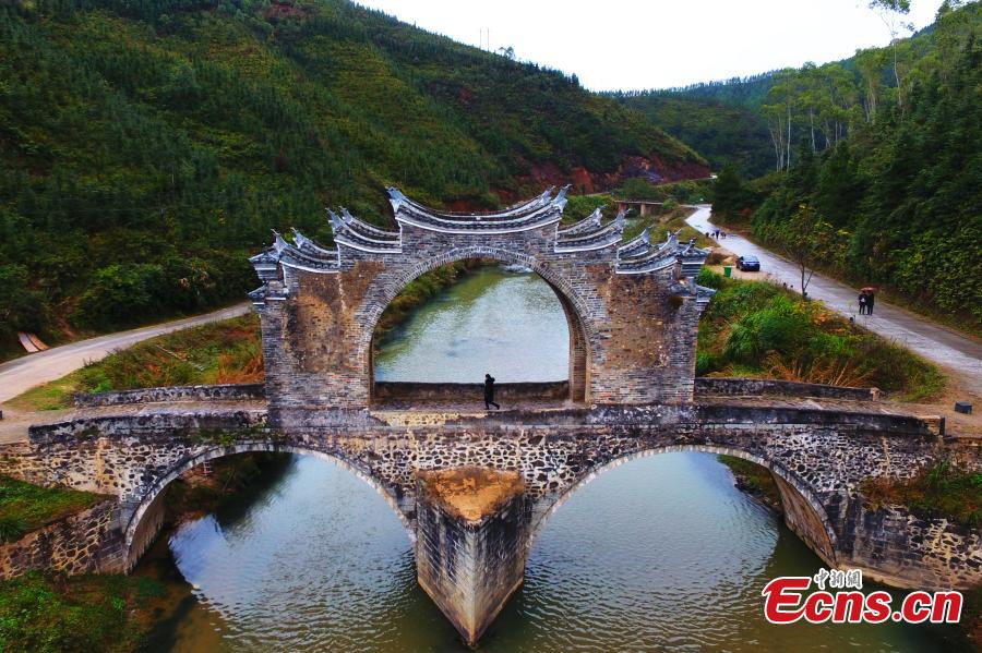 An aerial view of Taiping Bridge (Peace Bridge) in Longnan County, Jiangxi Province, Dec. 9, 2018. The double-layered stone bridge has two archways at the bottom and one on the top, a rare design. Built during the Ming Dynasty (1368-1644), the 50-meter-long bridge is now a cultural relic under national protection. (Photo: China News Service/Liu Zhankun)