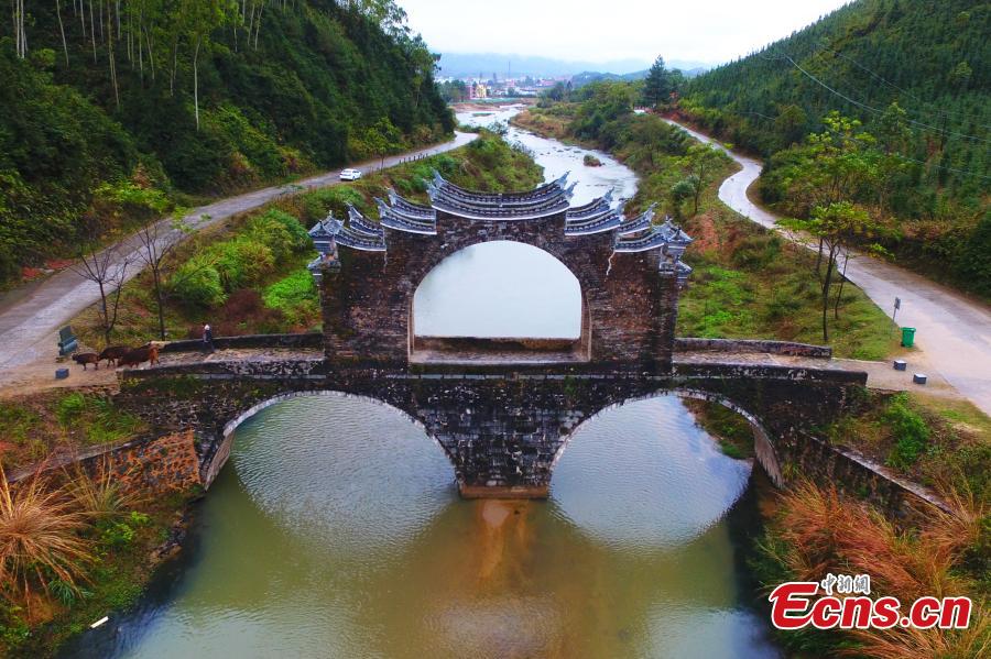 An aerial view of Taiping Bridge (Peace Bridge) in Longnan County, Jiangxi Province, Dec. 9, 2018. The double-layered stone bridge has two archways at the bottom and one on the top, a rare design. Built during the Ming Dynasty (1368-1644), the 50-meter-long bridge is now a cultural relic under national protection. (Photo: China News Service/Liu Zhankun)