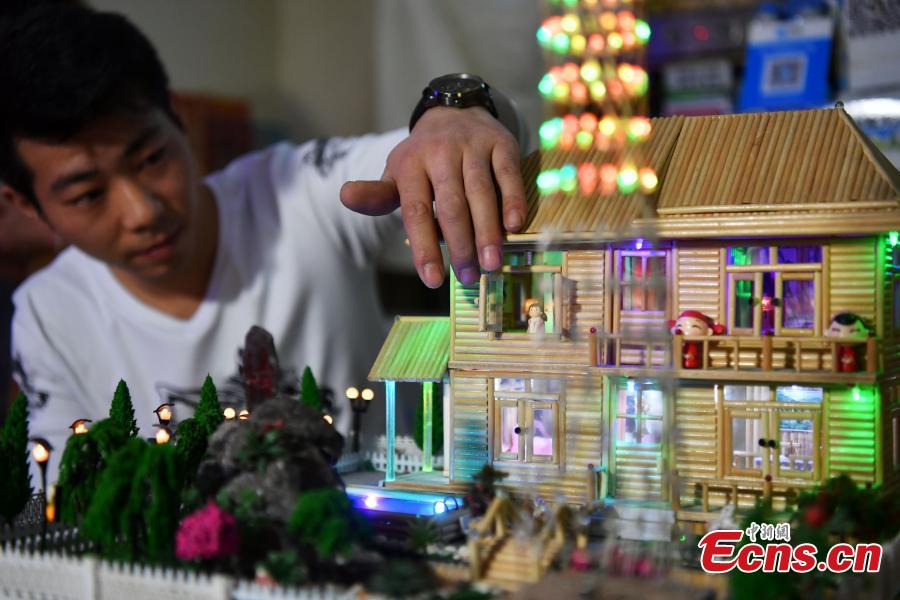 Xu Ruibin shows the openable window on a building made using bamboo skewers at his wonton restaurant in Shijiazhuang City, Hebei Province, Dec. 10, 2018. Xu said he taught himself the handicraft in three months and is now able to make various designs. In the past two years, he has created over 300 works, including landmark buildings and elaborate villa miniatures. (Photo: China News Service/Zhai Yujia)